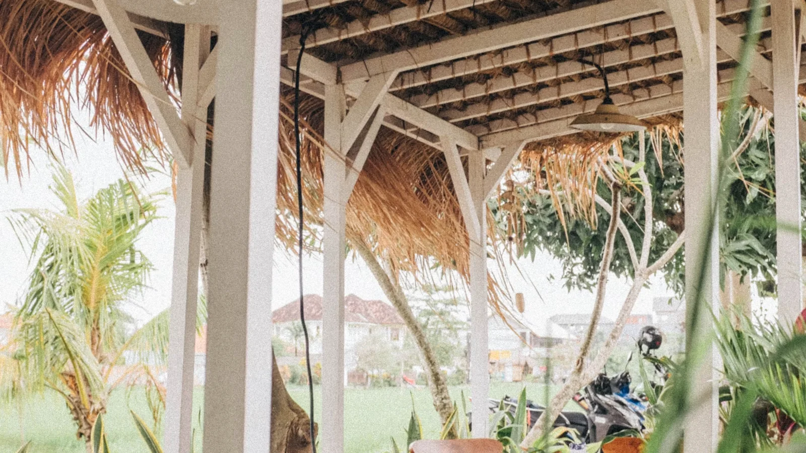 Area duduk terbuka di Canggu dengan meja kayu dan suasana tropis